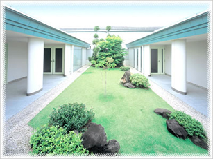 芝生が広がる開放的な中庭と両脇に並ぶ平屋の建物