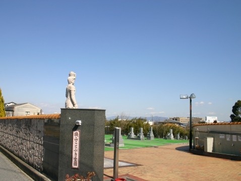 青空の下に立つ観音像と狭山ことぶき霊園の入り口