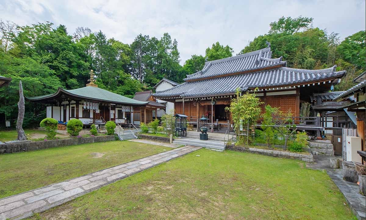 伝統的な瓦屋根が美しい寺院の本堂と芝生の境内