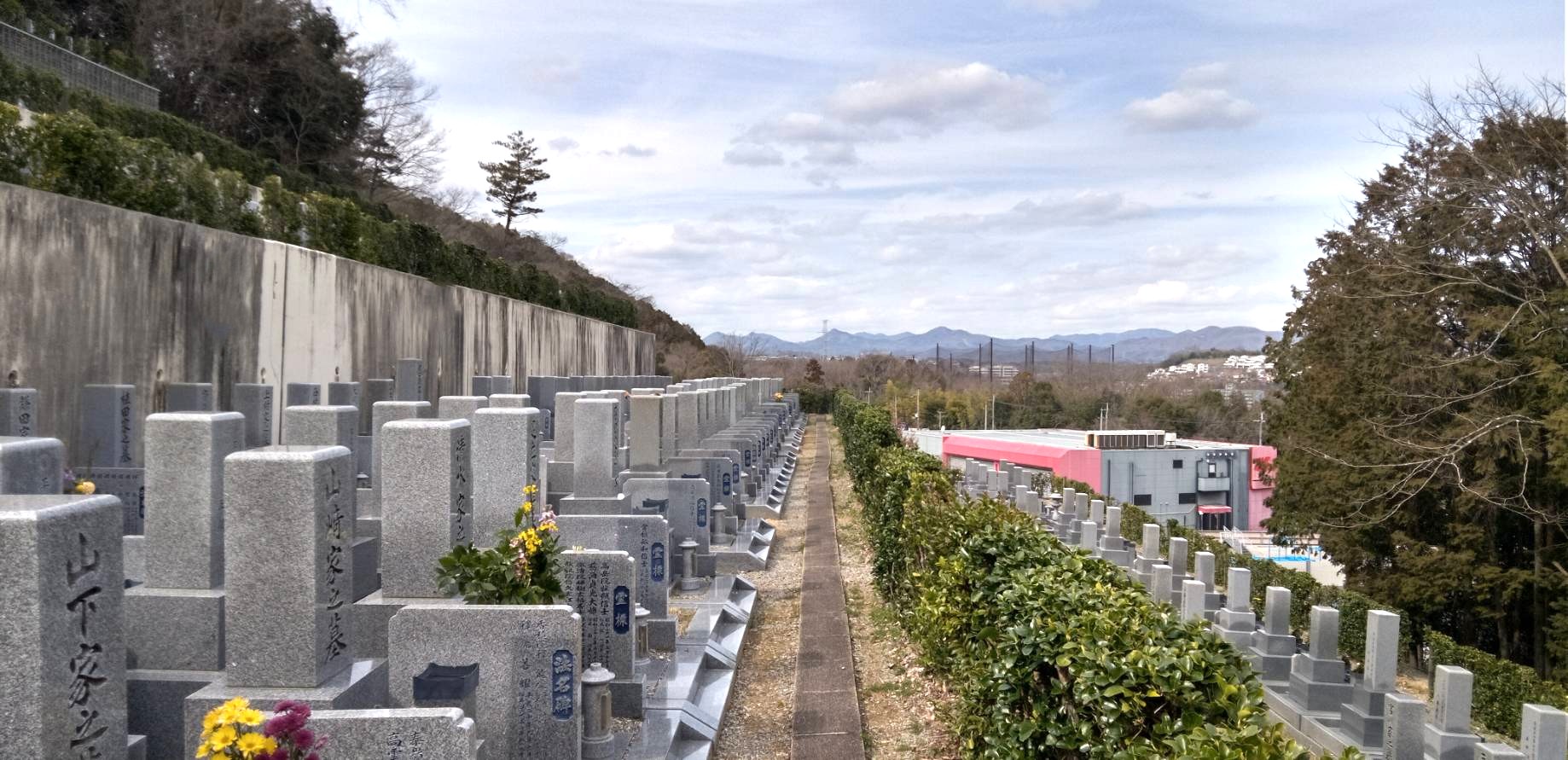 見晴らしの良い高台に位置する福田寺霊園の和型墓石群と遠方の山々