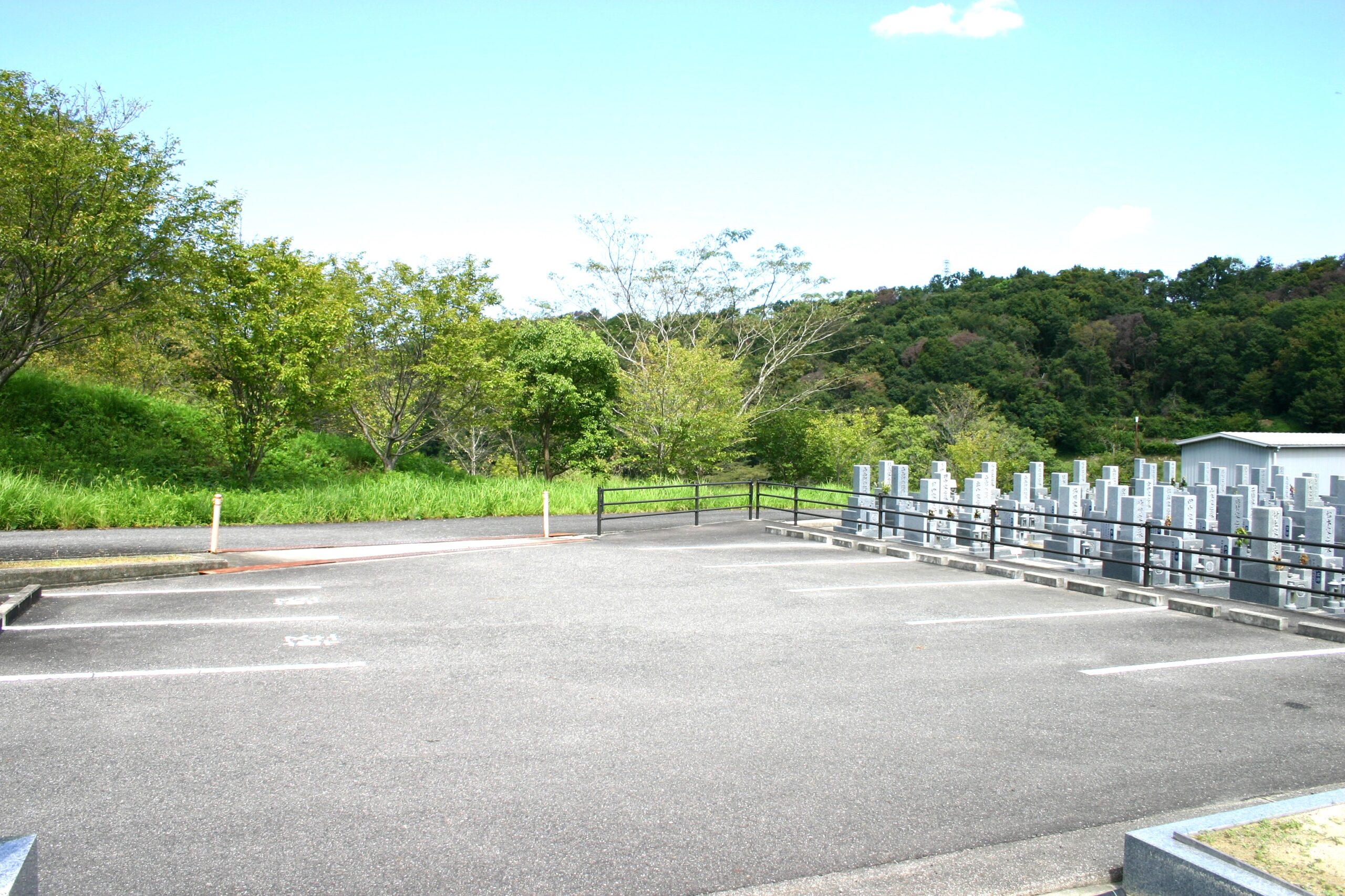 墓地のすぐ横に隣接するアスファルト舗装の駐車場