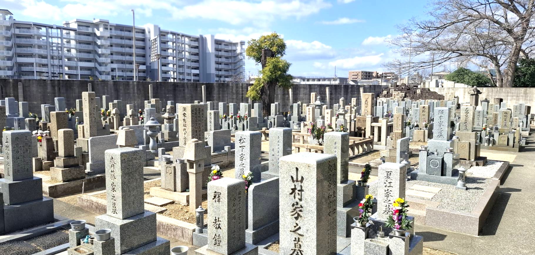 近代的なマンションを背にした本源院の現代的な墓地風景