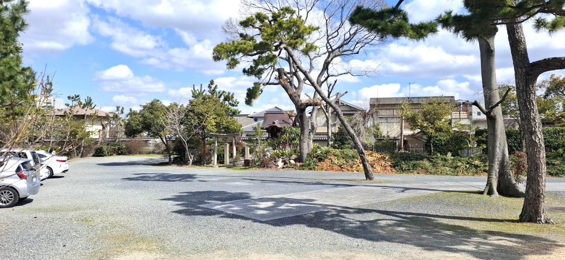 本源院の広々とした砂利敷きの駐車場と奥に見える鳥居