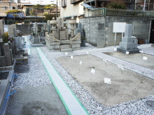 寺院内に整然と並ぶ石造りの墓石と新しい墓地用の区画