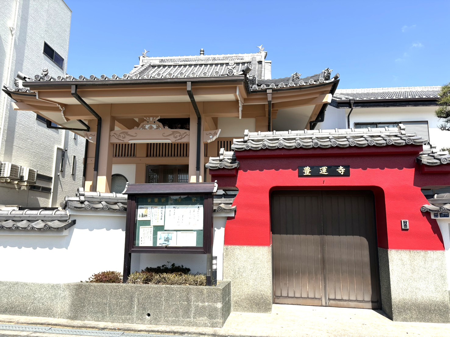赤い門と近代的な本堂が特徴的な豊運寺の正面外観