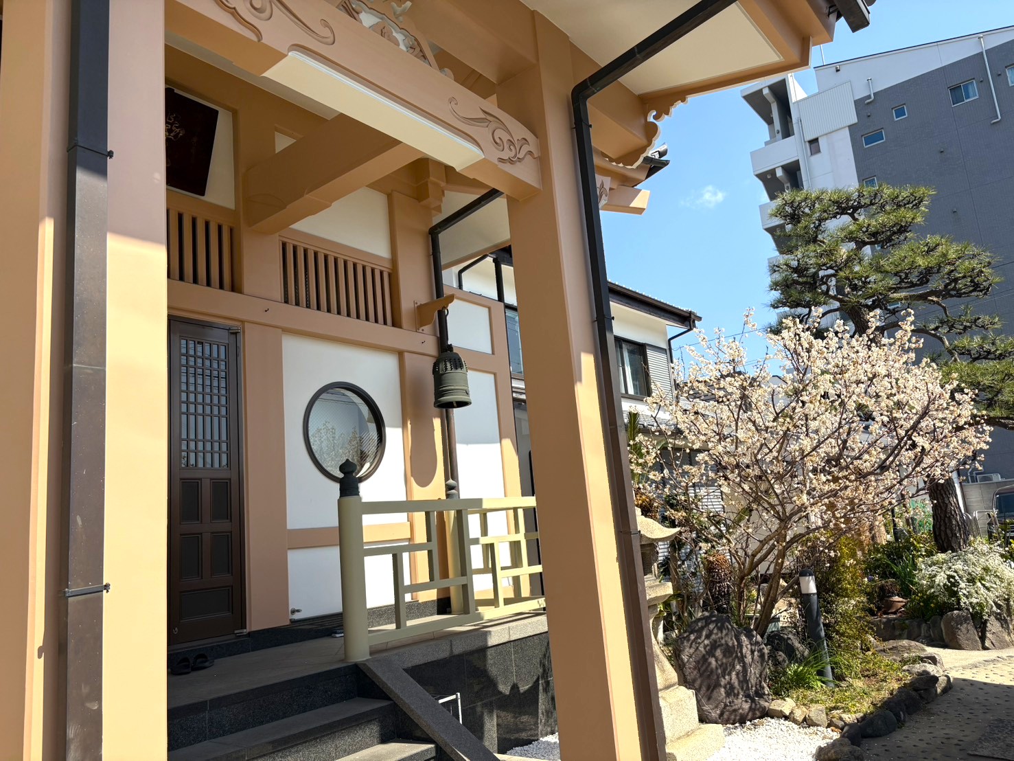 白い梅の花が咲く豊運寺の本堂入り口と円窓の様子