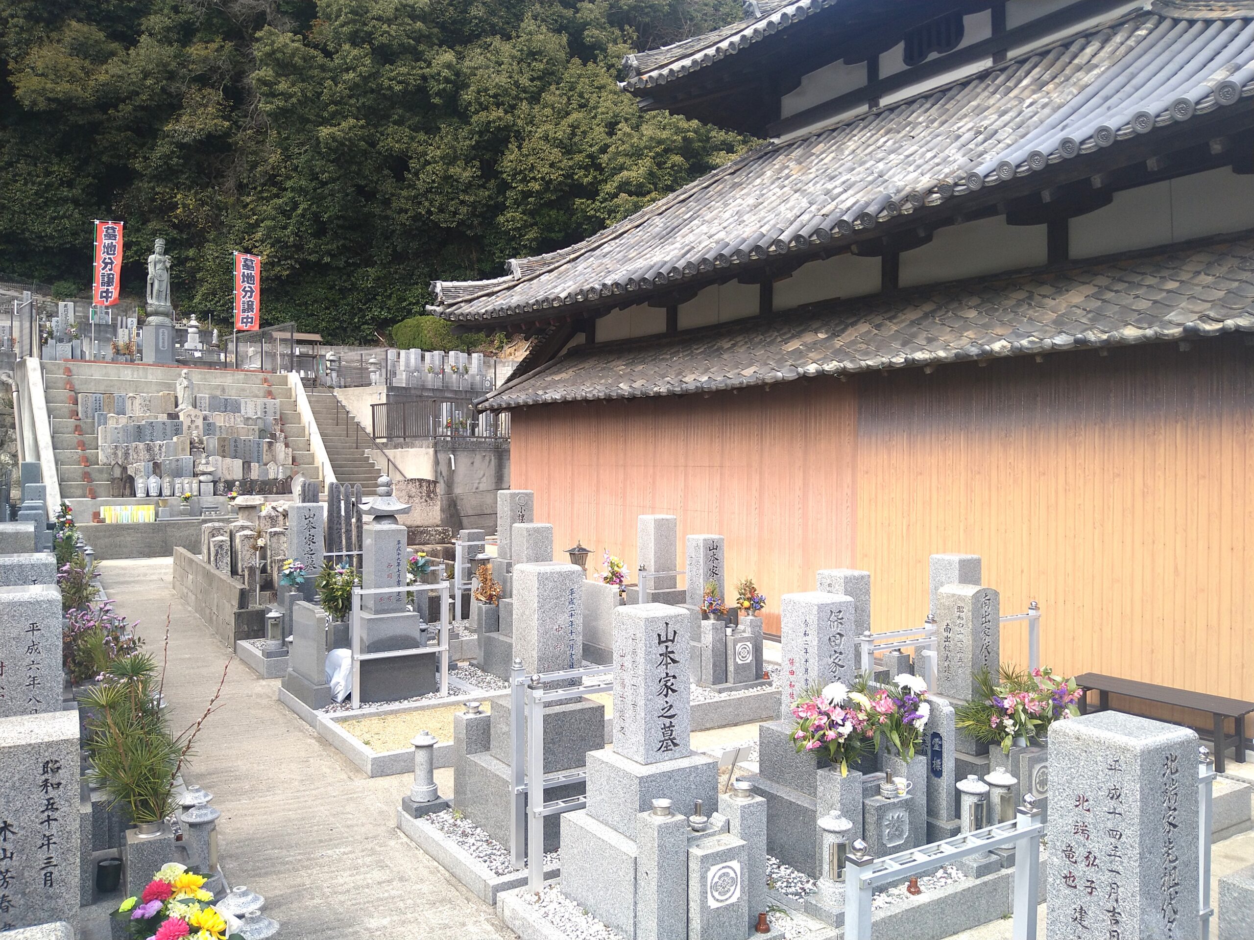 寺院の本堂と隣接する日当たりの良い墓地エリア