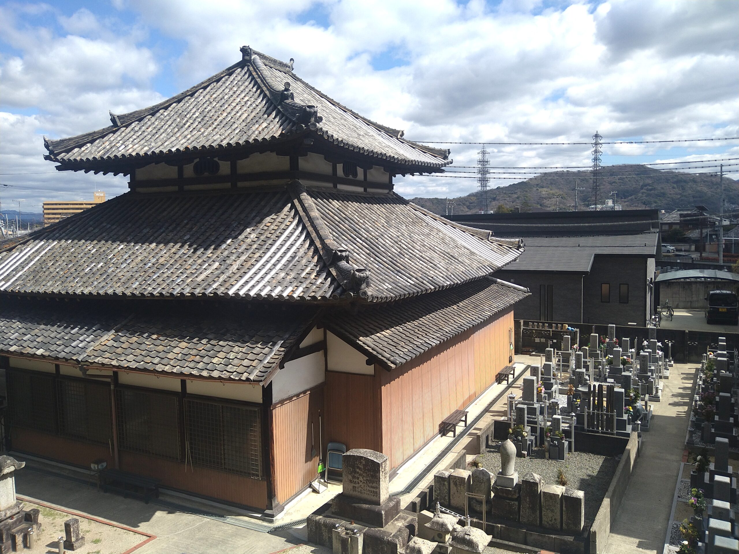 高台から見下ろす寺院の本堂と墓地のパノラマ
