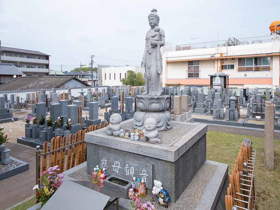子供を抱いた慈母観音像と足元の可愛らしい石像