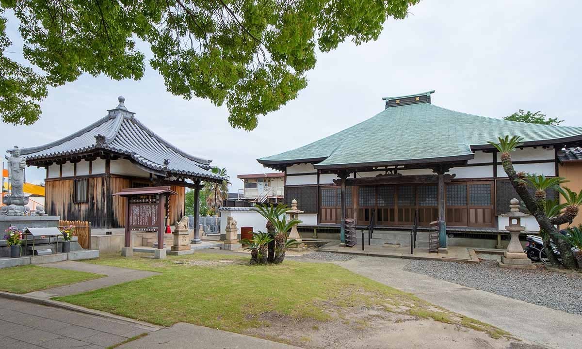 本堂と観音像が並ぶ寺院境内の静かな風景