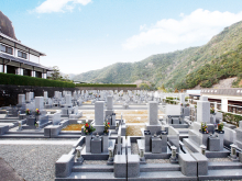 青空と山並みに囲まれた日当たりの良い霊園の区画