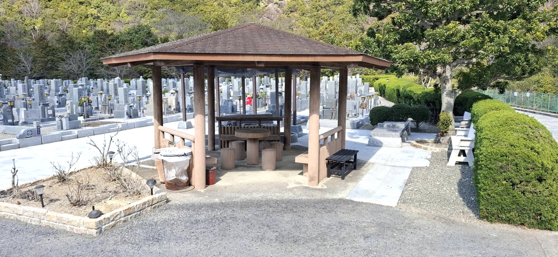奥水間霊園内にある木造の東屋と丸いテーブルベンチ