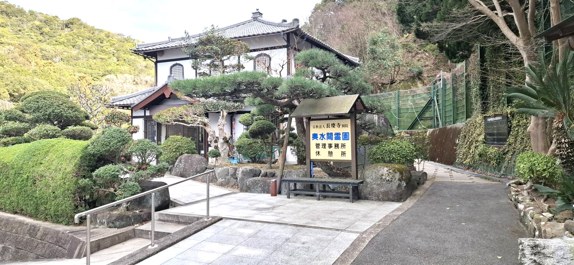 奥水間霊園の入り口に立つ管理事務所と案内看板