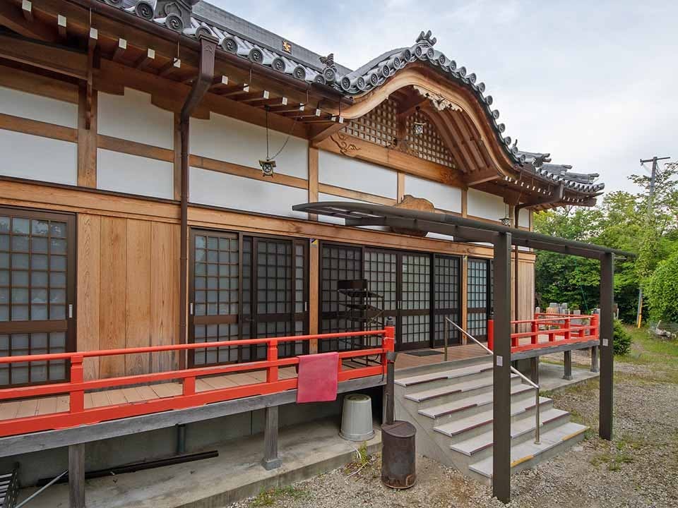 朱色の欄干が特徴的な伝統的な日本建築の寺院本堂