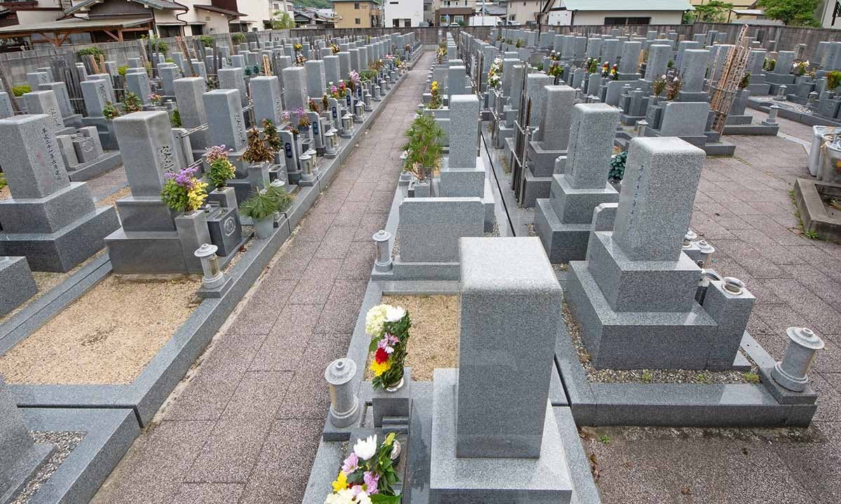グレーの御影石で作られた和型墓石が並ぶ寺院墓地