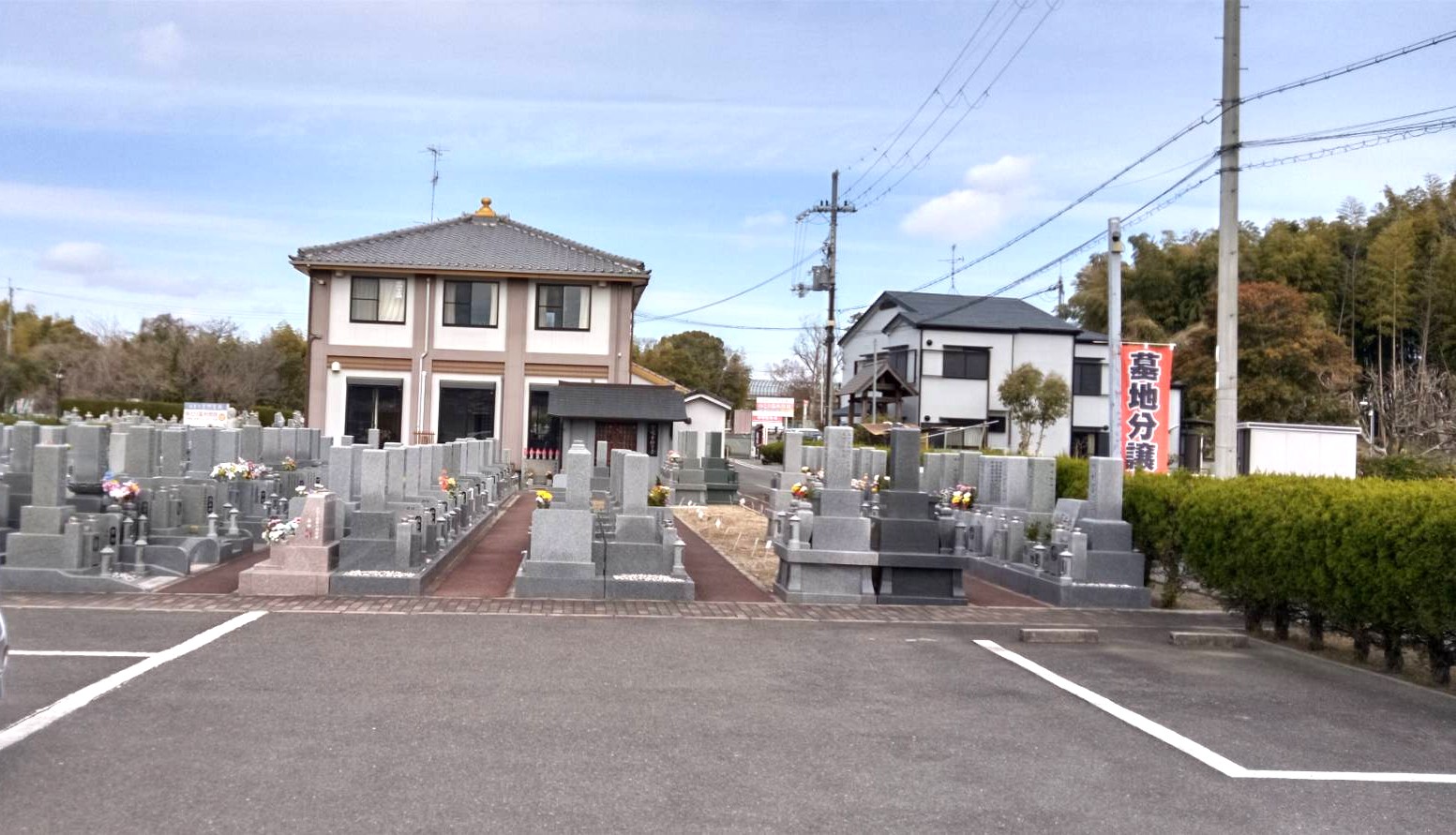 駐車場から見た章園寺の墓地全景と「墓地分譲」の赤い幟