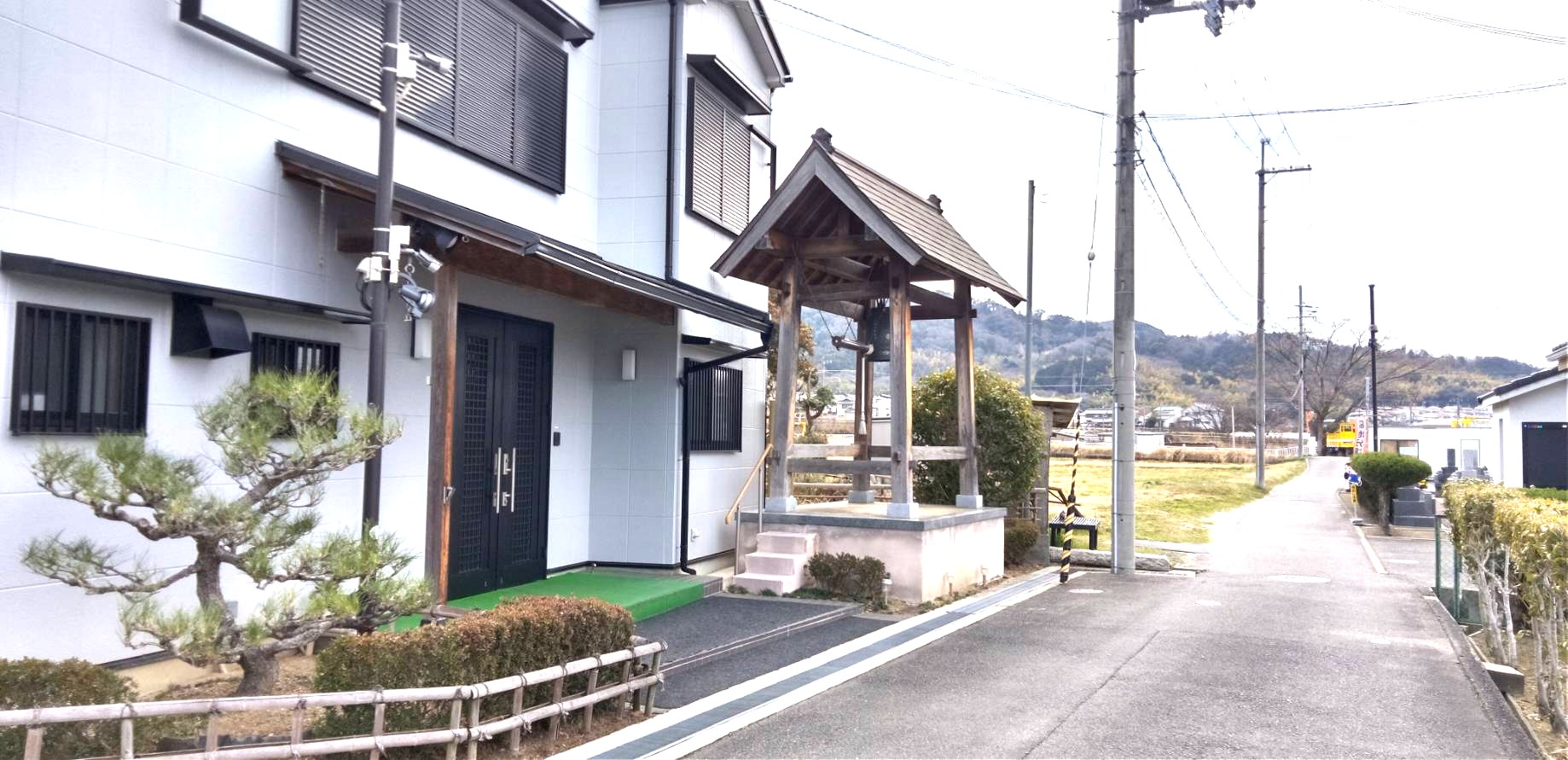 章園寺の敷地内にある木造の鐘楼堂と近代的な寺院の建物