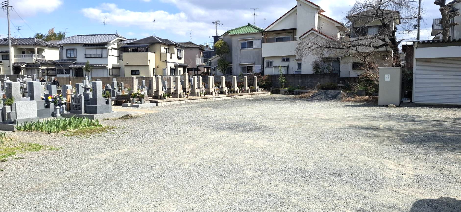住宅街に隣接する開放的で広々とした砂利敷きの駐車場