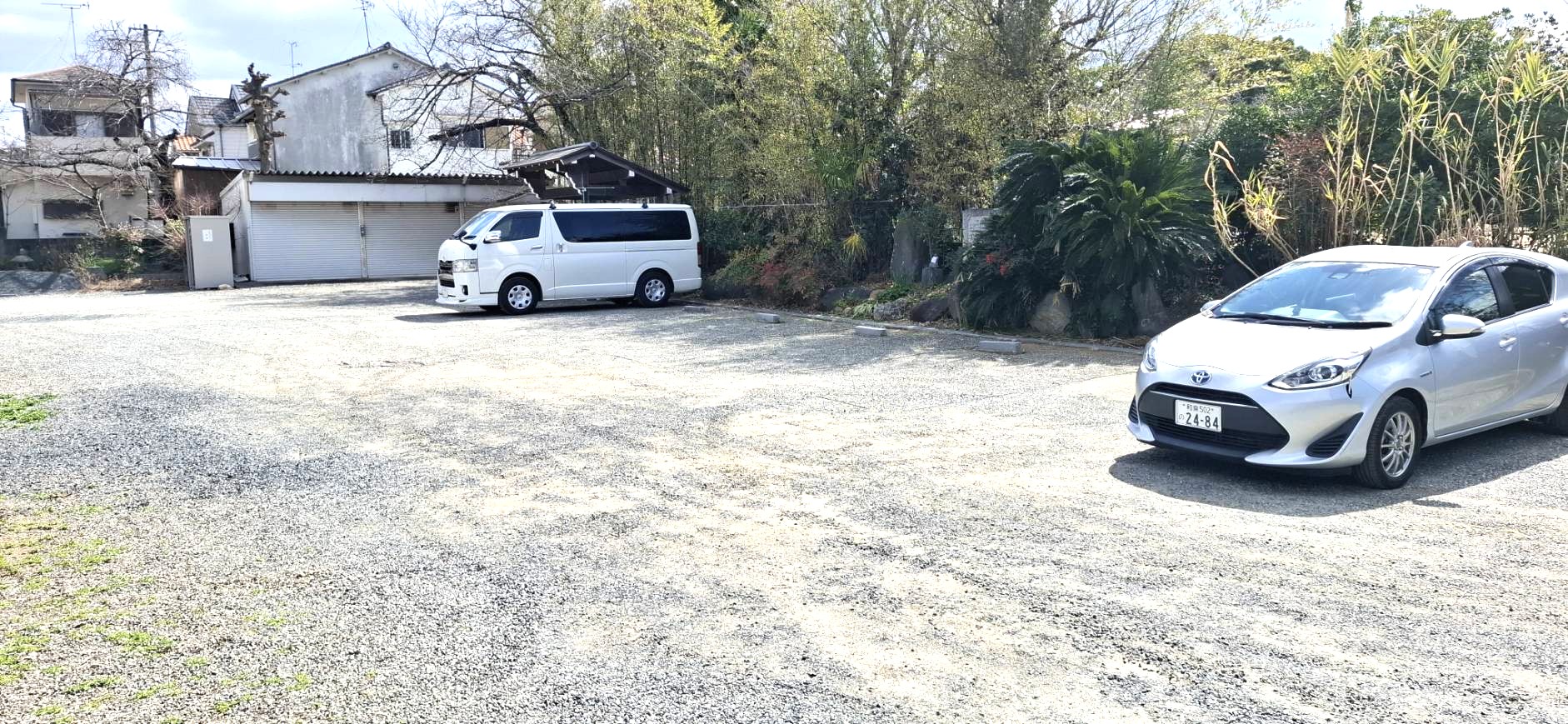 乗用車が停車している広々とした砂利敷きの参拝者用駐車場