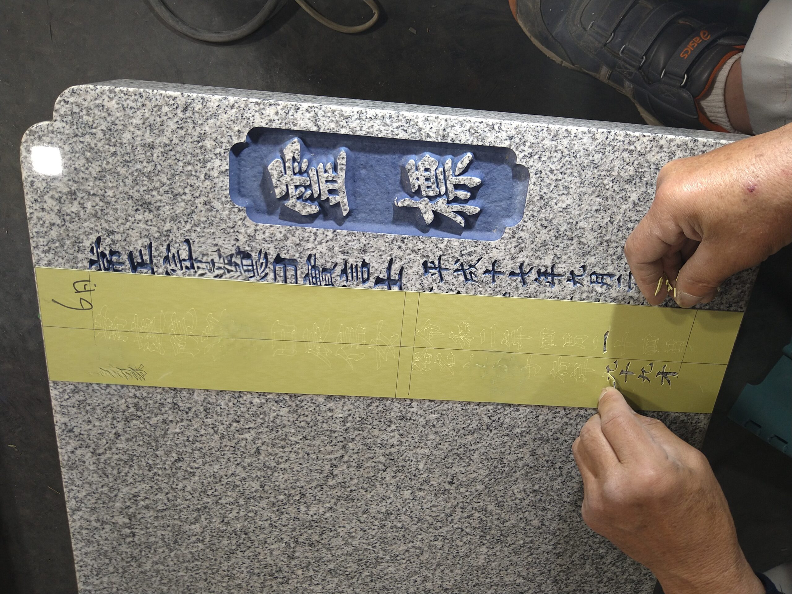 彫刻前の準備段階で、戒名の形に合わせて丁寧に型抜きされるゴムシート