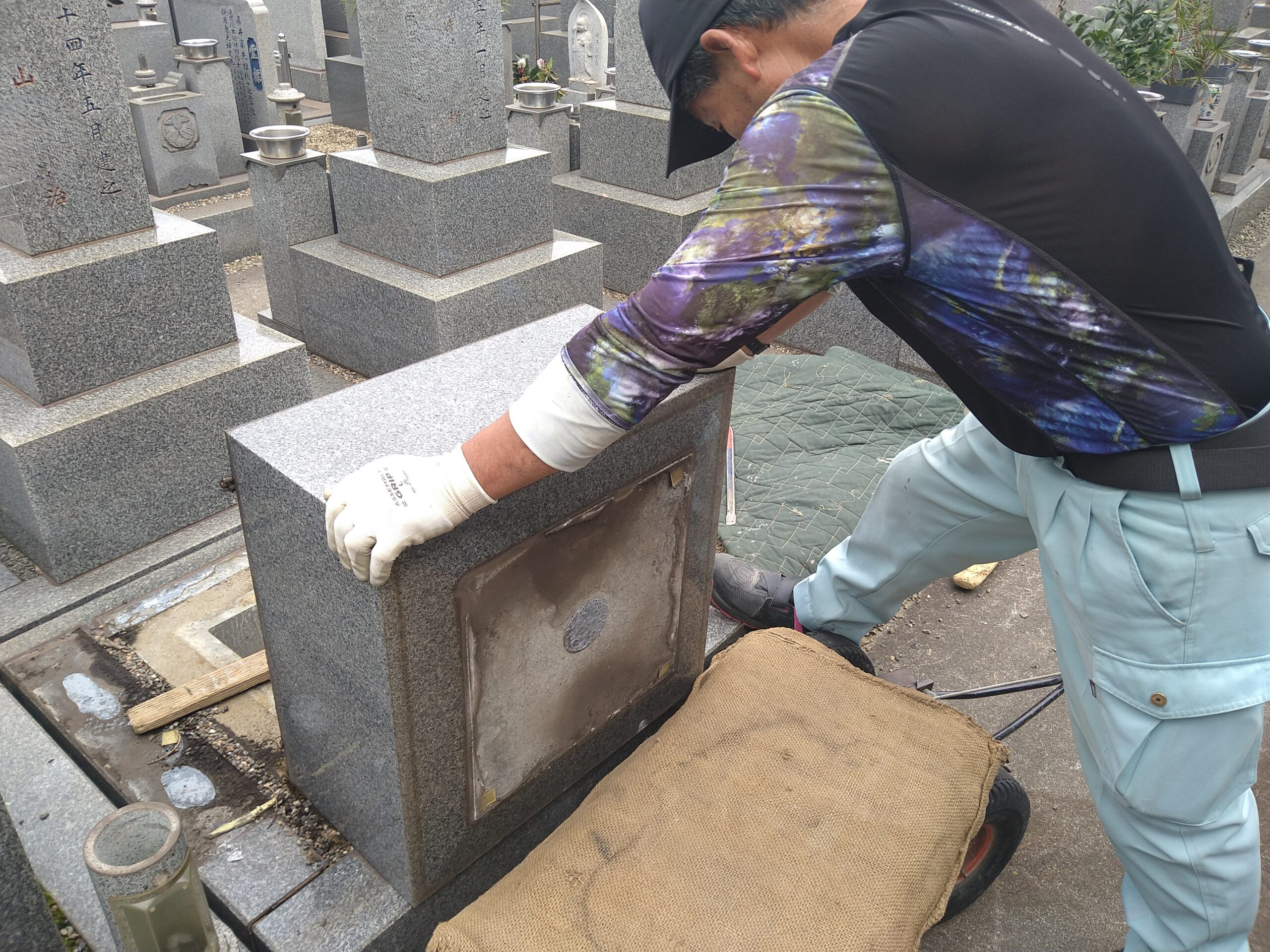 墓石の石材表面を手作業で丁寧に磨く作業